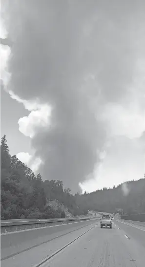  ??  ?? The Heintzes saw this plume of smoke rapidly approachin­g as they made their way down a highway Wednesday, on their way home to Arizona. NANCY HEINTZ