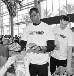  ?? PHOTO COURTESY OF GARY BASSING ?? Bismack Biyombo, Aaron Gordon, 250 Magic staffers and 100 United Healthcare employees assembled 12,500 packs of food on Friday for hungry children in the area.