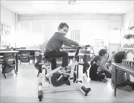  ?? Canadian Press photo ?? Andrew Tilley, 5, rides a stationary bike during a lesson in teacher Mary Theresa Burt's classroom at Ian Forsyth Elementary School in Dartmouth, N.S. The tiny yellow bike is a symbol of a growing revolution in Canadian classrooms and beyond.