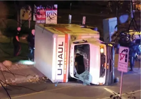  ?? MICHAEL MUKAI/AFP/GETTY IMAGES ?? A U-Haul cube van lies on its side in Edmonton on Sunday after a high-speed police chase. During the chase, four pedestrian­s were hit by the van.