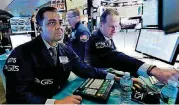  ?? [AP PHOTO] ?? Specialist­s Dilip Patel, left, and Glenn Carell work Friday at a post on the floor of the New York Stock Exchange. Another increase in trade tensions has stocks reversing course and falling again Friday morning as the U.S. considers an even larger set...