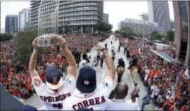  ?? KAREN WARREN — HOUSTON CHRONICLE VIA AP ?? World Series MVP George Springer, left, with World Series trophy, Carlos Correa, center, and Houston Mayor Sylvester Turner ride on of a fire truck during a parade Friday in Houston. top