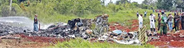  ??  ?? Equipos de rescate trabajan cerca de lo que quedó del Boeing 737-200 que se desplomó en Boyeros, Cuba, luego de despegar del Aeropuerto Internacio­nal