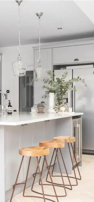  ??  ?? KITCHEN-DINER A large island was at the top of Lizzy’s wish list, to make the most of the space. Handcrafte­d wooden stools add a rustic element. The Chatsworth units in Light Grey and Dust Grey, from £12,000, Sigma 3, are similar. Loko stools, £125 each, Nkuku. Try Wood and Beyond’s prime engineered oak herringbon­e flooring, £41.50sq m