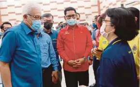  ?? ZAM PIC BY SHARUL HAFIZ ?? Home Minister Datuk Seri Hamzah Zainudin (left) and Tambun member of parliament Datuk Seri Ahmad Faizal Azumu (in red shirt) talking to the public attending the Program Malaysia Prihatin at Dewan Serbaguna Bandar Baru Tambun yesterday.