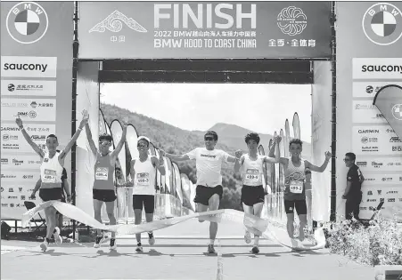  ?? PROVIDED TO CHINA DAILY ?? BMW Hood to Coast China runners cross the finish line together at Wanlong Paradise Resort on Saturday.