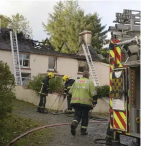  ??  ?? Fatal fire: Firefighte­rs at the house where a man’s body was found at Shanagh, north east of Dunmanway, Co Cork