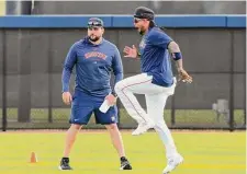  ?? ?? Astros catcher Martín Maldonado, right, hops as he warms up during the first day of workouts.