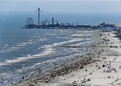  ?? Yi-Chin Lee / Houston Chronicle ?? Hundreds enjoyed the clear day Friday on Stewart Beach in Galveston. The blue water off Galveston over the past weekend has been driving a surge in tourism, but conditions are moving the fisherman-friendly sea back to brown.