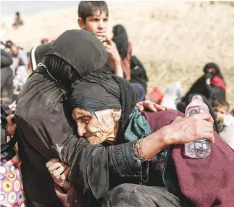  ?? — Reuters ?? Khatla Ali Abdullah, 90, is embraced as she flees her home as Iraqi forces battle with IS militants in western Mosul on February 27.