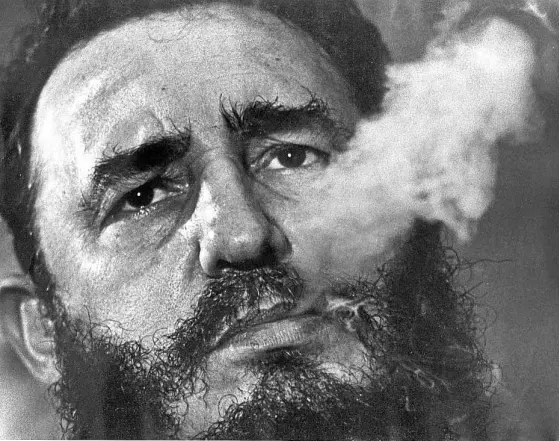  ?? —AP ?? The death of Fidel Castro, seen in this 1985 file photo smoking a cigar, has generated mixed reactions in the United States, where he has been described by Cuban exiles as a tyrant who turned his country into a garrison state.