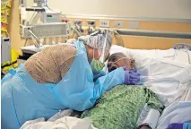  ?? FILE PHOTO] ?? In this July 31 photo, Romelia Navarro, 64, weeps while hugging her husband, Antonio, in his final moments in a COVID-19 unit at St. Jude Medical Center in Fullerton, Calif. [JAE C. HONG/ASSOCIATED PRESS