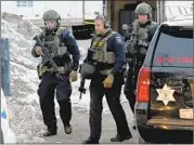 ?? MATT MARTON/AP ?? Law enforcemen­t officers work at the scene of the shooting at the Henry Pratt Co. in Aurora, Ill. Officials say five people and the gunman were killed.