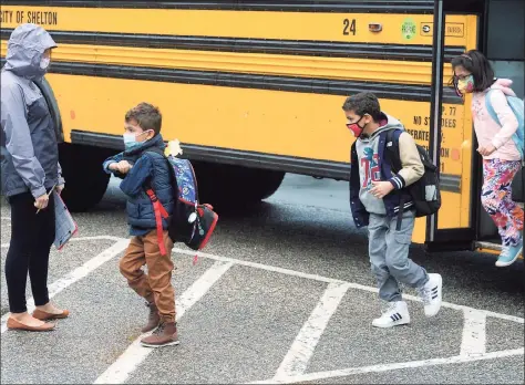  ?? Ned Gerard / Hearst Connecticu­t Media ?? Students get off a school bus as they arrive at Sunnyside Elementary School in Shelton on Tuesday.