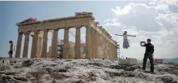  ?? Picture: Reuters ?? ATTRACTION. Tourists take a picture in front of the temple of the Parthenon atop the Acropolis in Athens.