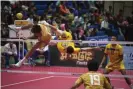  ?? Photograph: Lillian Suwanrumph­a/
AFP/Getty Images ?? A sepak takraw player from Thailand rollspikes the ball over the net against Singapore.
