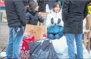  ?? CP PHOTO ?? People sit with bags of Boxing Day sale purchases at the McArthur Glen Designer Outlet mall, in Richmond, B.C., on Dec. 26, 2017.
