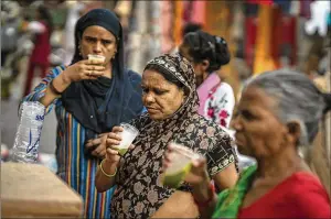  ?? ALTAF QADRI/AP ?? Shoppers drink juice in plastic glasses at a weekly market in New Delhi, India, Wednesday. India banned some single-use or disposable plastic products Friday as a part of a longer federal plan to phase out the ubiquitous material in the nation of nearly 1.4 billion people.