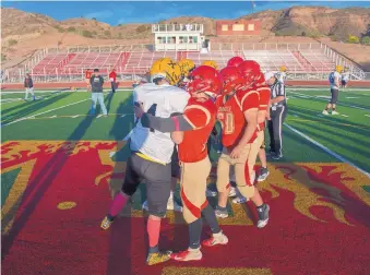  ?? EDDIE MOORE/JOURNAL FILE ?? Members of the St. Pius and Española Valley football teams shake hands before their game in October in Española. Because of previous unruly fan behavior, the NMAA prohibited home fans from attending.