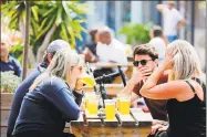  ?? Getty Images ?? People enjoy a drink at Gabriel’s Wharf beside the River Thames in London on Friday.