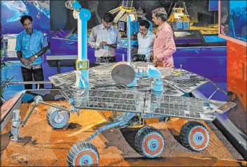  ?? Manjunath Kiran
Tribune News Service ?? Visitors look at a replica of NASA’S Mars Opportunit­y rover during its unveiling ceremony in June at an industrial museum in Bangalore, India.