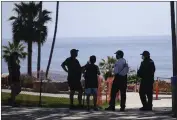  ?? MARCIO JOSE SANCHEZ — THE ASSOCIATED PRESS FILE ?? Visitors talk to police officers in front of a closed-off beach in Laguna Beach on May 3, 2020.