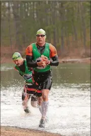  ?? CONTRIBUTE­D BY TIM NETTLETON ?? Marcus Barton, left, and Dan Kimball of Team Orca emerge from the water during SwimRun Georgia. The team placed first in the overall long course.