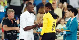  ?? Reuters ?? Usain Bolt awards the silver medal to Shericka Jackson of Jamaica. —