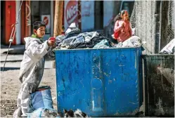  ?? ?? A Palestinia­n boy inspects a garbage container as he looks for cartons to make a fire, in the Rafah refugee camp in the southern Gaza Strip. (AFP)