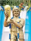  ?? Agence France-presse ?? ↑ A sculpture of Maradona being readied before an event in Kolkata, after his death.
Right: An employee takes pictures of a statue of Maradona inside Mother’s Wax Museum in Kolkata.