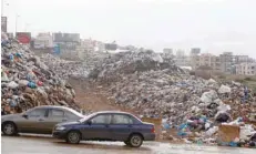 ?? — Reuters ?? Cars pass past piled up garbage in Jiyeh, Lebanon, last week.