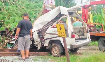  ??  ?? What’s left of the van that crashed into the train at Kampung Memanjang in Beaufort yesterday. — Bernama photo