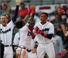  ?? JOHN BAZEMORE — THE ASSOCIATED PRESS ?? From left to right, Atlanta Braves’ Freddie Freeman, Ozzie Albies and Johan Camargo celebrate after Charlie Culberson hit a walkoff two-run home run in the ninth inning of the first game of a baseball doublehead­er against the Mets, Monday in Atlanta.