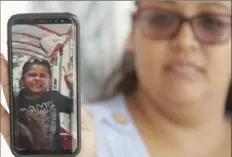  ?? Associated Press ?? Josephine Guicho holds her phone Monday, showing a photo of her 6- year- old nephew, Stephen Romero, in San Jose, Calif. Stephen is one of three people who died when a gunman opened fire at a popular California food festival Sunday.