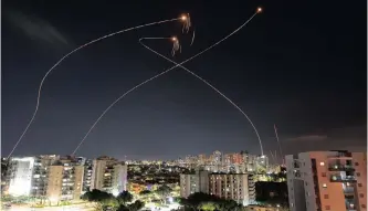  ?? | REUTERS ?? STREAKS of light are seen from Ashkelon, on Thursday as Israel’s Iron Dome anti-missile system intercepts rockets launched from the Gaza Strip on Israel.