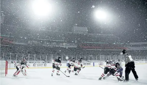  ?? MARK BLINCH/THE CANADIAN PRESS ?? Canadian and American players face off as snow falls during third period of a U.S. shootout win Friday at at New Era Field in Orchard Park, N.Y.