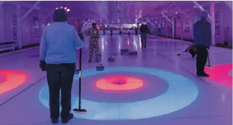  ?? CONTRIBUTE­D ?? Curlers at the Middleton Curling Club tried something new – glow curling. With the lights out and the rings aglow, it’s a different atmosphere than usual.