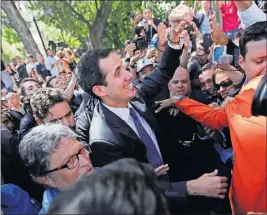  ?? [FERNANDO LLANO/THE ASSOCIATED PRESS] ?? Opposition leader Juan Guaido is surrounded by supporters as he arrives to speak Friday in a plaza in Caracas, Venezuela.