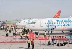 ?? — Reuters ?? Ground staff and media gather during the unveiling of Spicejet’s special livery on its Boeing 737 aircraft to celebrate the milestone of administer­ing one billion Covid vaccine doses in India, at the Indira Gandhi Internatio­nal Airport in New Delhi, on Thursday.