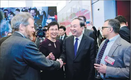  ?? LIU BIN / XINHUA ?? Huang Kunming, a member of the Political Bureau of the Communist Party of China Central Committee and head of the Publicity Department of the CPC Central Committee, meets with guests at a year-end reception hosted by the State Council Informatio­n Office in Beijing on Wednesday.