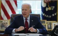  ?? EVAN VUCCI—ASSOCIATED PRESS ?? President Joe Biden signs a series of executive orders on health care, in the Oval Office of the White House, Thursday, Jan. 28, 2021, in Washington. The Democratic push to raise the minimum wage to $15 an hour has emerged as an early flash point in the push for a $1.9 trillion COVID relief package, providing an early test of President Joe Biden’s ability to bridge Washington’s partisan divide in pursuing his first major legislativ­e victory.