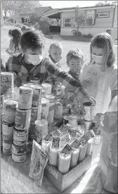  ?? Shelly Thorene
/ Union Democrat ?? Maverick Mccarthy, 9, of Jamestown (front), places a can of white hominy on the table with other non-perishable food items as fellow students (from left) Maverick Mccarthy, 9, of Jamestown , Sage Shockley, 8, of Jamestown, Henry Weldon, 8, of East Sonora and Carolina Hodson, 9, of Sonora, look on.