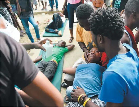  ?? PHOTO AFP ?? Des personnes blessées lors de la catastroph­e sont soignées dans la cour de l’hôpital Immaculée Conception de Port-de-paix.