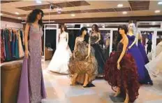  ?? AFP ?? Few takers for the evening wear and wedding dresses that are displayed in a showroom in Mosul.