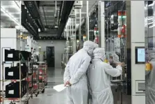  ?? LUO XIAOGUANG / XINHUA ?? Technician­s of Semiconduc­tor Manufactur­ing Internatio­nal Corp inspect the company’s facilities in Beijing.