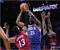  ?? MATT SLOCUM — THE ASSOCIATED PRESS ?? The 76ers’ Joel Embiid, who had 18points in his return, goes up for a shot against the Heat’s Bam Adebayo and P.J. Tucker in Game 3.