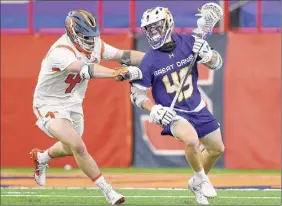  ?? Rich Barnes / Syracuse Athletics ?? Ualbany midfielder Graydon Hogg had two goals in a 13-8 loss. Here, he doges Syracuse defender/midfielder Brandon Aviles during the first half.