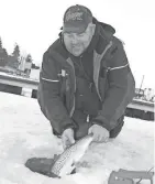  ?? PAUL A. SMITH / MILWAUKEE JOURNAL SENTINEL ?? Ken Poludniany­k of Milwaukee releases a brown trout caught while ice fishing in the Kenosha harbor.