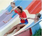  ??  ?? FOLLOW THE LEADER... Trainer lifeguards help kids through the slide and teach them safety tips.