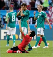  ?? ASSOCIATED PRESS ?? GERMANY’S PLAYERS walk off the pitch as South Korea’s Ju Se-jong (front) celebrates after their group F match Wednesday in the Kazan Arena in Kazan, Russia, Wednesday.